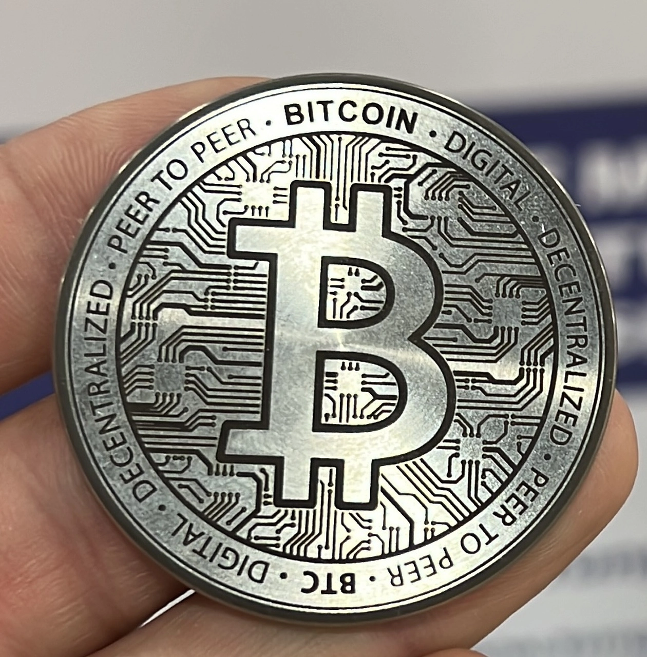 An engraved Tungsten casascius coin with the bitcoin logo